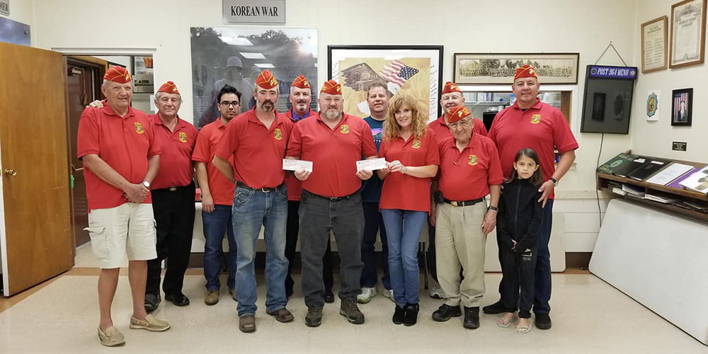 Detachment members standing in formation in scarlet shirts and red covers