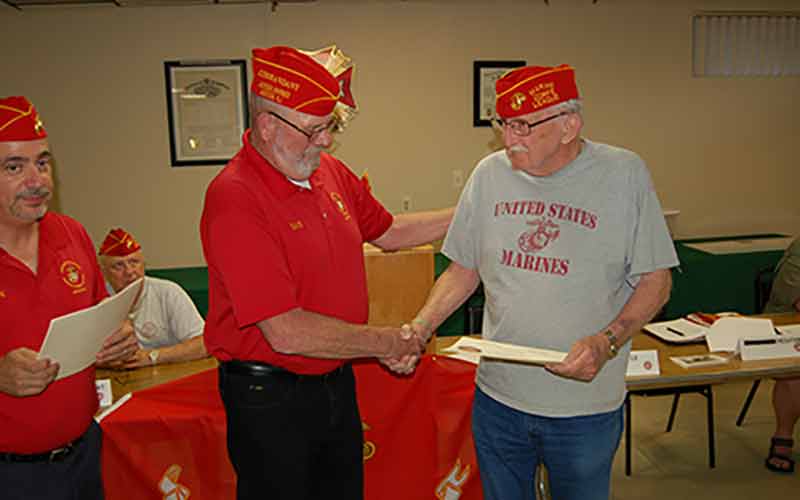 Detachment members presenting a large ceremonial check for veterans assistance